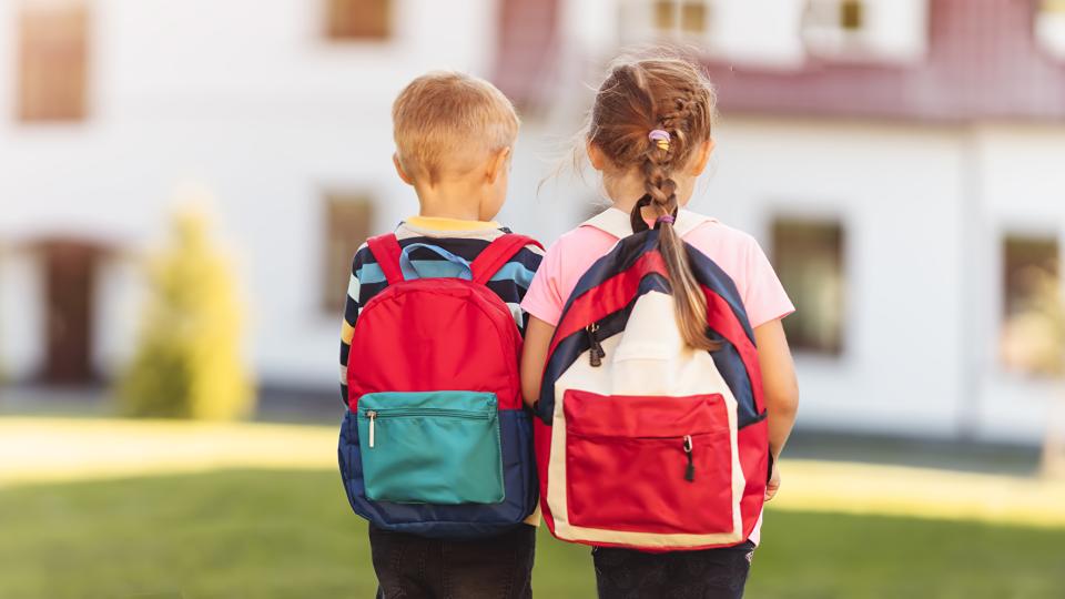 Kinder mit Rucksäcken auf dem Weg zum Kindergarten