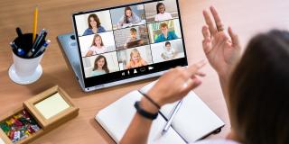 Lehrer moderiert Online-Unterricht mit Videokonferenz am Laptop